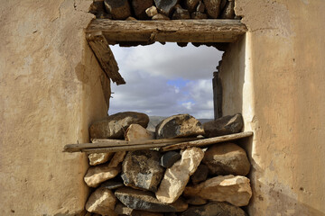  Fensterdurchbruch in einer alten Mauer mit Steinen halb aufgefüllt.