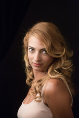 Naklejka premium ritratto di bellissima ragazza bionda che guarda intensamente in macchina - sfondo nero