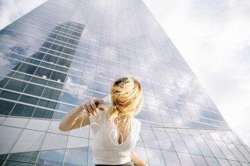 Fototapeta premium Young blond woman listening to music outdoors