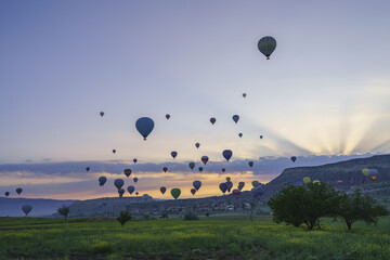 Sunrise in Cappadocia, Turkey, with balloons and typical fairy chimney.