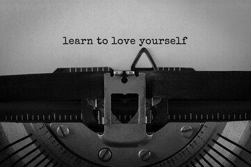 Text Learn to love yourself typed on retro typewriter