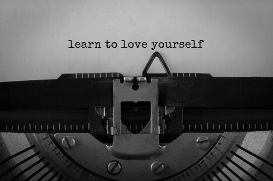 Text Learn to love yourself typed on retro typewriter