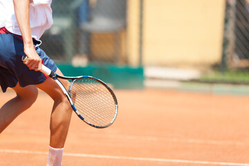 Fototapeta na wymiar Boy playing tennis. Detail. Large copy on the right.