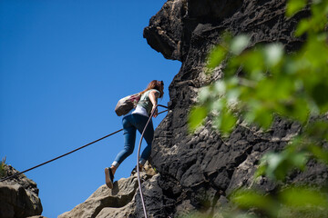 Junge Frau benutzt während einer Wanderung einen Klettersteig