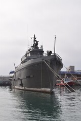 Naklejka premium Altes Kriegsschiff vor Anker im Hafen, der Himmel voller Wolken