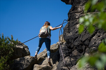 Junge Frau benutzt während einer Wanderung einen Klettersteig