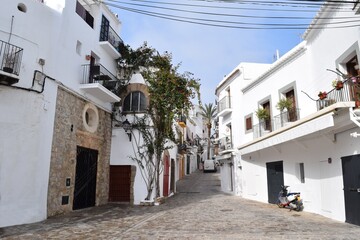 Fototapeta na wymiar Straßenszene in der Dalt Vila, Ibizas befestigter Altstadt vor blauem Sommerhimmel