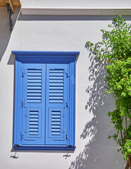 blue shutters window on white wall