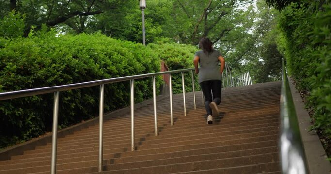 A young Indian woman runs up a flight of stairs during her exercise.