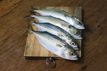 Mackerel Fish On Wooden Chopping Board With Dramatic Light And Vignette Effect