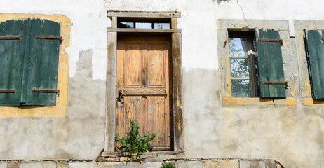 Altes Haus mit Holztür und grünen Fenster