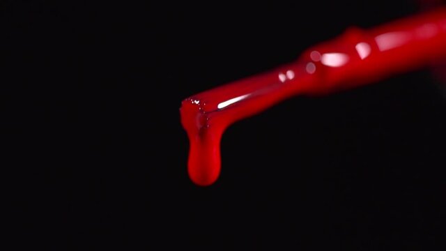 Clsoeup of a red nail polish drpping into the bottle slow motion