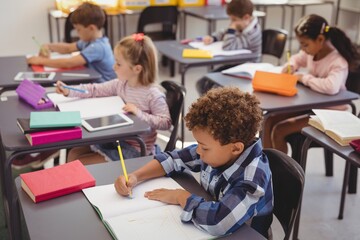Attentive schoolkids doing their homework in classroom