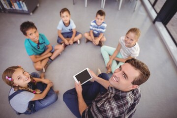 Overhead view of teacher and kids using tablet 