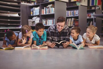 Fototapeta premium Teacher and schoolkids lying on floor 