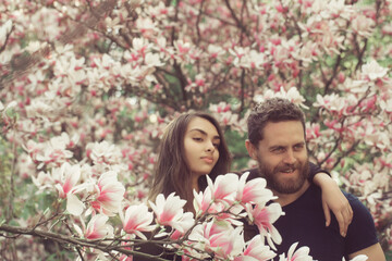 woman hugging happy, smiling man at magnolia trees