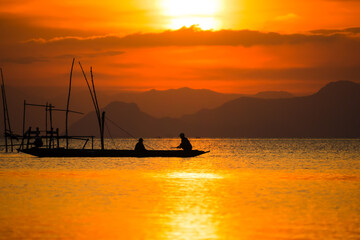 Silhouettes of fisherman at the lake, Thailand.