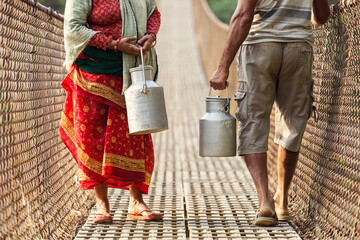 People carrying milk on the bridge in Himalaya Mountain, Nepal - obrazy, fototapety, plakaty