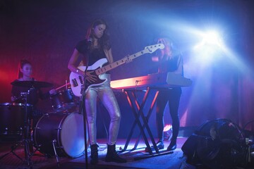Obraz na płótnie Canvas Females performing on illuminated stage in nightclub
