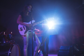 Fototapeta na wymiar Confident female singer playing guitar 