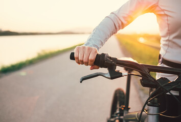 Close up woman hand on the bicycle handlebars