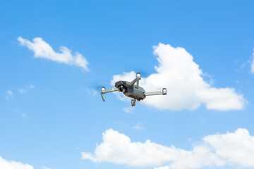 Fototapeta na wymiar Black drone against a blue sky with clouds.