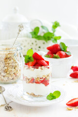 Dessert in a glass with granola, yogurt and strawberries. Useful breakfast.