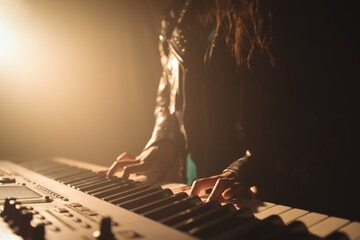Mid section of female musician playing piano