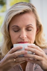 Close up of businesswoman smelling coffee cup