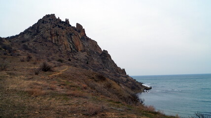 View of the black sea at the foot of the mountains under the sky in the clouds