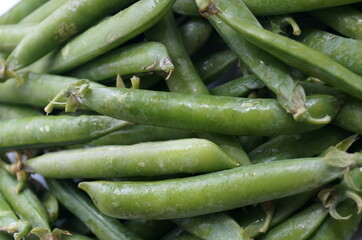 Green peas in pods are on the table