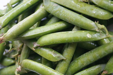 Green peas in pods are on the table