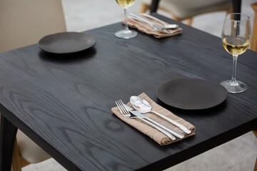 High angle view of eating utensils by wineglasses on table