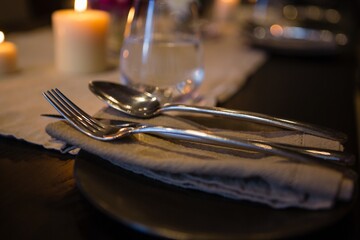 Close up of cutlery and napkin on table