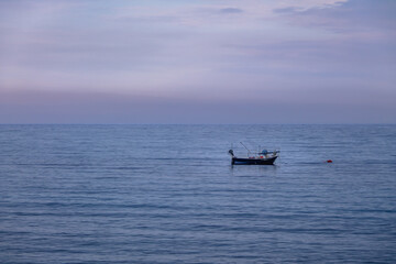A boat in a Mediterranean beach of Ionian Sea at sunset - Bova Marina, Calabria, Italy