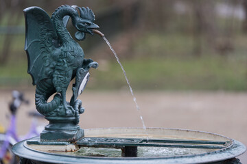 Symbol of a basilisk on water fountain. - obrazy, fototapety, plakaty
