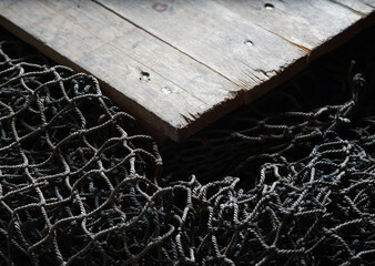 Fishing nets over wooden background with copy space. © Acronym