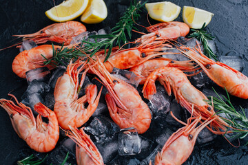 Tiger shrimps with lime, lemon, rosemary and black pepper spices on stone background.