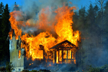 Home on fire as the flames burst through the windows, door and roof of the house