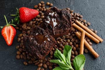Muffin on a dark background with coffee beans and strawberries