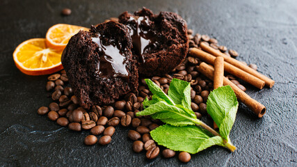 Muffin on a dark background with coffee beans and orange