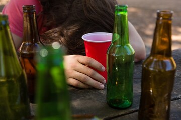Drunk man leaning on the table holding a glass