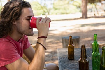 Man drinking beer from disposable glass