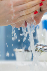 Woman washing face in bathroom. Hygiene.