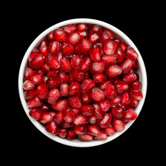 Grains Of Pomegranate In A White Bowl Isolated On Black Background. Close-Up. Top View.