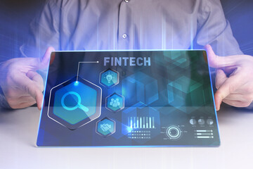 Fototapeta premium Business, Technology, Internet and network concept. Young businessman working on a virtual screen of the future and sees the inscription: Fintech