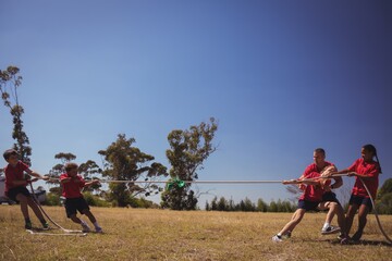 Kids playing tug of war during obstacle course training