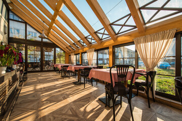 Tables in modern restaurant interior and big skylight