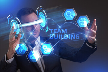 Business, Technology, Internet and network concept. Young businessman working in virtual reality glasses sees the inscription: Team building