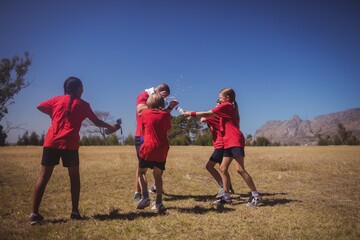 Kids having fun with the trainer in the boot camp